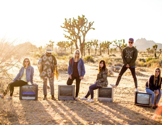 group of six people standing on desert