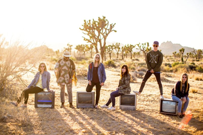 group of six people standing on desert