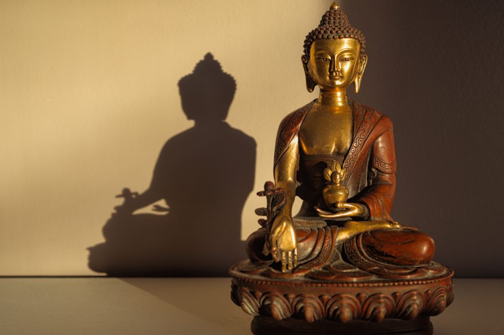 gold buddha figurine on white table