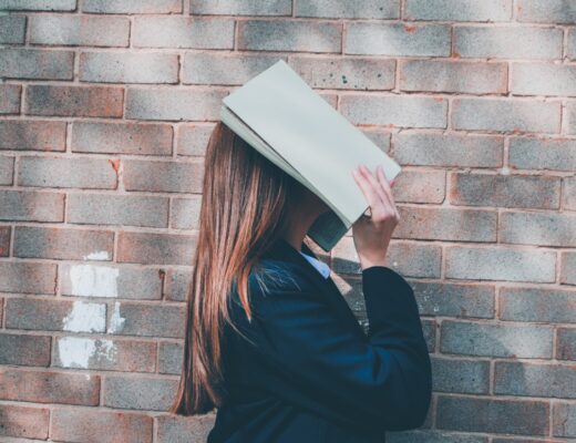woman covering her face with an open book